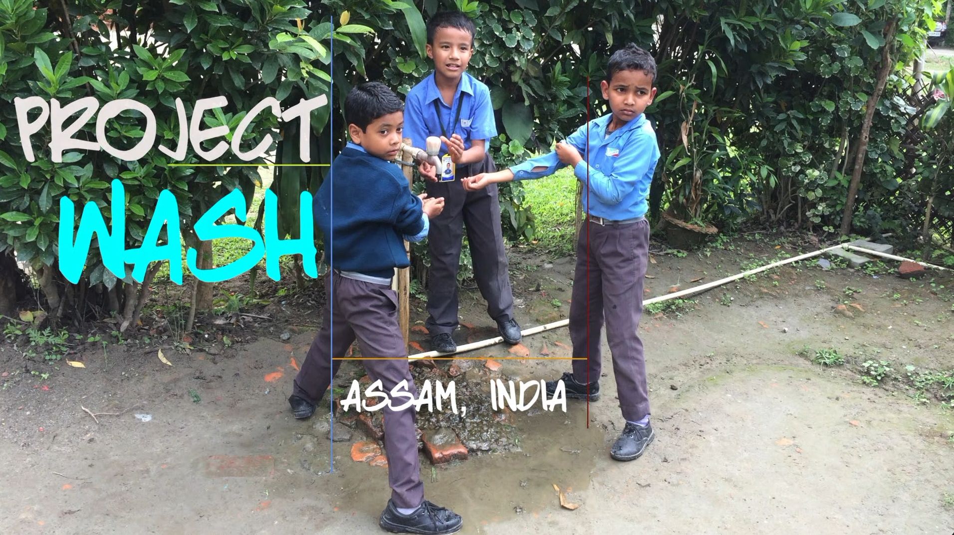 Title card from Project WASH. Three schoolchildren in blue uniforms wash their hands at an outdoor bamboo tap stand in Assam, with the words “Project WASH, Assam, India” overlaid.